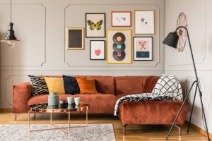 Gallery of trendy posters in elegant grey living room interior with brown corner sofa