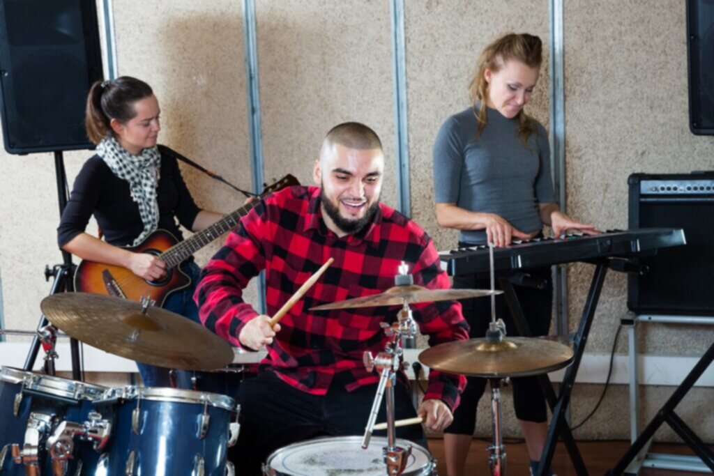 Drummer, keyboardist and guitar player, playing in a sound treated garage