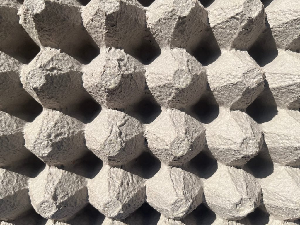 Rough, uneven surface from egg crates. Poorly installed to try and work as soundproofing, which will not work.