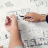 Engineer and architect discussing about blueprint layout design of electricity plan before construction