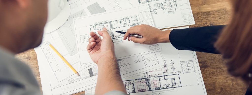 Engineer and architect discussing about blueprint layout design of electricity plan before construction