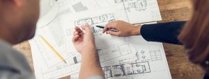 Engineer and architect discussing about blueprint layout design of electricity plan before construction